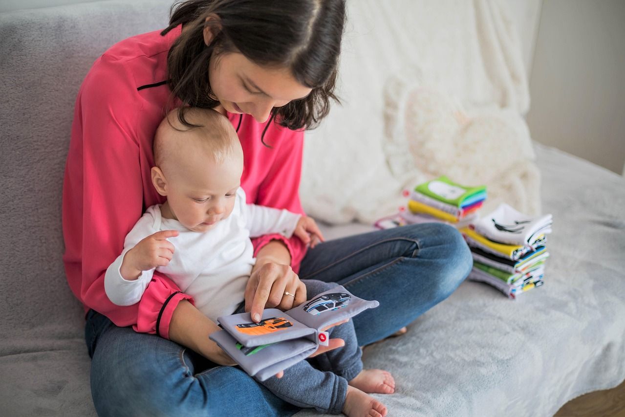 A mother holding her baby in a bright living room